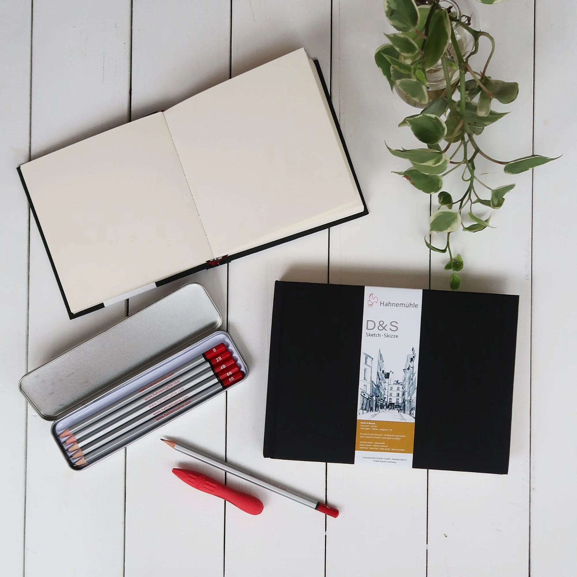 notebook, sketchbook, pencils, pencil case, red pen